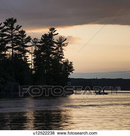 Boat on a lake at sunset, Lake of The Woods, Ontario, Canada View Large Photo Image Stock Photo - Boat on a lake at sunset, Lake of The Woods, Ontario, Canada. Fotosearch