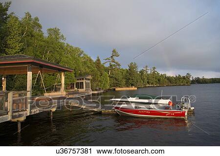 Stock Image - Boats at a dock, Lake Of The Woods, Keewatin, Ontario, Canada. Fotosearch