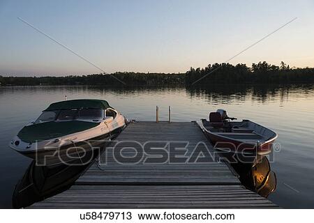 Stock Image - Boats moored at a dock, Lake of The Woods, Keewatin, Ontario, Canada. Fotosearch