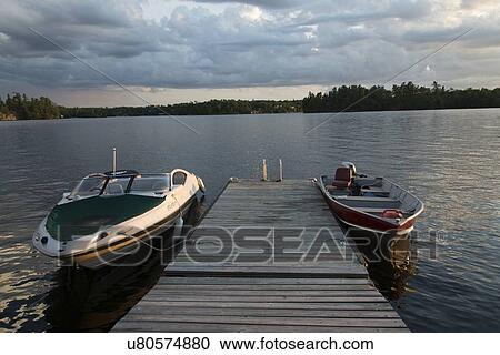 Stock Image - Boats moored at a dock, Lake of The Woods, Keewatin, Ontario, Canada. Fotosearch