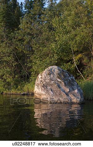 Stock Photo - Boulder on the shoreline, Lake of The Woods, Keewatin, Ontario, Canada. Fotosearch