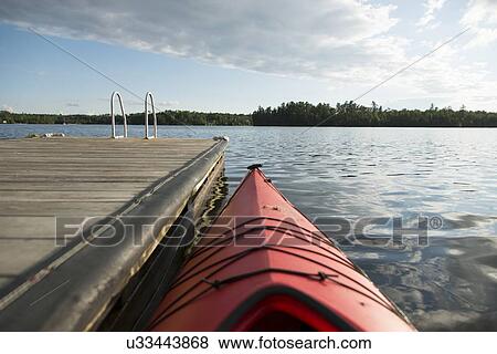 Stock Photo - Canoe at a dock, Lake Of The Woods, Keewatin, Ontario, Canada. Fotosearch