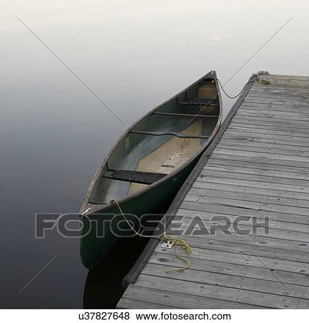 Stock Photo - Canoe beside a wooden dock, Lake of The Woods, Ontario, Canada. Fotosearch