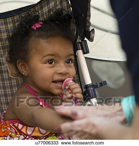 Stock Image - Close-up of a cute little girl in a stroller, Branson, Taney County, Missouri, USA. Fotosearch