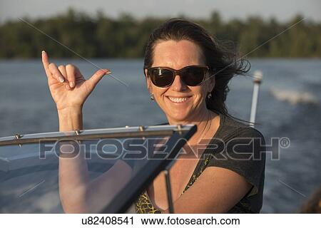 Close-up of a woman gesturing and smiling on a motorboat, Lake of The Woods, Keewatin, Ontario, Canada View Large Photo Image Stock Image - Close-up of a woman gesturing and smiling on a motorboat, Lake of The Woods, Keewatin, Ontario, Canada. Fotosearch