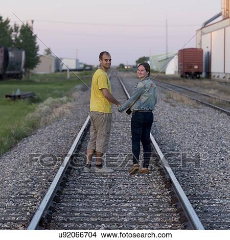 Couple standing between railroad tracks, Manitoba, Canada View Large Photo Image Picture - Couple standing between railroad tracks, Manitoba, Canada. Fotosearch