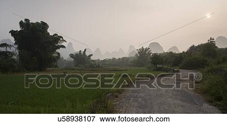 Dirt road passing through fields, Yangshuo, Guilin, Guangxi Province, China View Large Photo Image Stock Photo - Dirt road passing through fields, Yangshuo, Guilin, Guangxi Province, China. Fotosearch