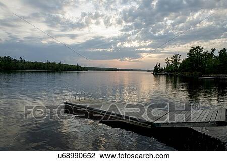 Stock Image - Dock at Lake of The Woods at sunset, Keewatin, Ontario, Canada. Fotosearch