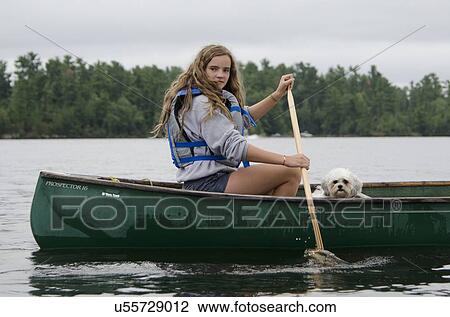 Stock Image - Girl boating in a lake, Lake of The Woods, Keewatin, Ontario, Canada. Fotosearch