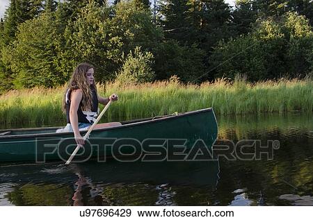 Stock Photo - Girl boating in a lake, Lake of The Woods, Keewatin, Ontario, Canada. Fotosearch