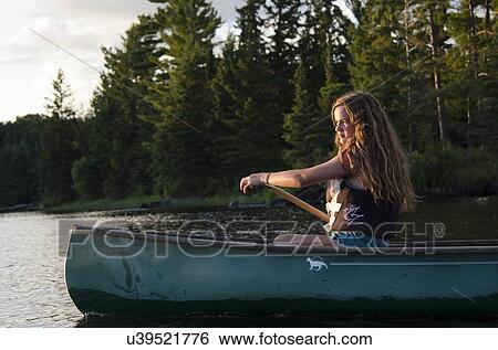 Stock Photograph - Girl boating in a lake, Lake of The Woods, Keewatin, Ontario, Canada. Fotosearch