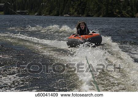 Stock Photo - Girl enjoying on an inflatable raft, Lake of The Woods, Keewatin, Ontario, Canada. Fotosearch
