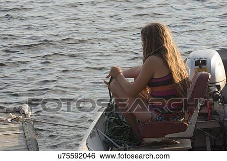 Girl sitting on a motorboat in a lake, Lake of The Woods, Keewatin, Ontario, Canada View Large Photo Image Stock Photograph - Girl sitting on a motorboat in a lake, Lake of The Woods, Keewatin, Ontario, Canada. Fotosearch