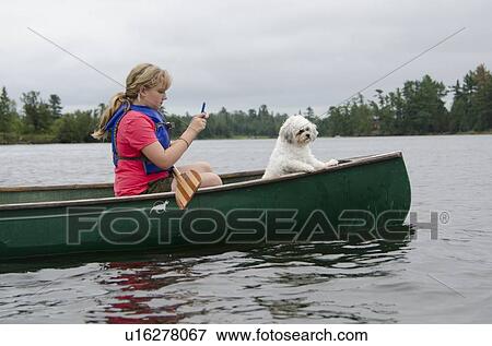 Girl using phone while boating in a lake, Lake of The Woods, Keewatin, Ontario, Canada View Large Photo Image Stock Photo - Girl using phone while boating in a lake, Lake of The Woods, Keewatin, Ontario, Canada. Fotosearch