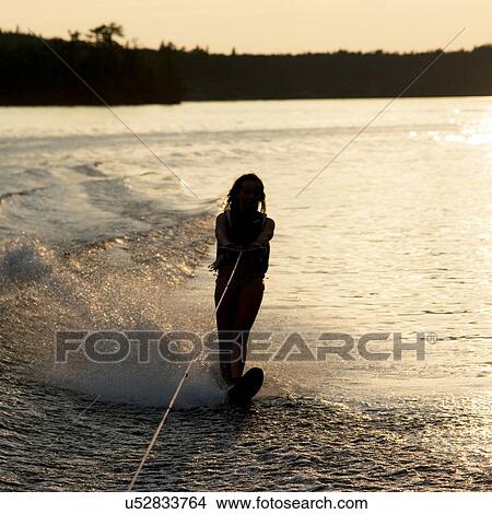 Picture - Girl waterskiing in a lake, Lake of The Woods, Keewatin, Ontario, Canada. Fotosearch