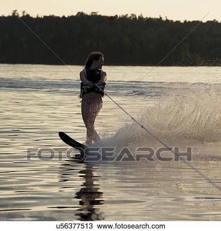 Stock Image - Girl waterskiing in a lake, Lake of The Woods, Keewatin, Ontario, Canada. Fotosearch
