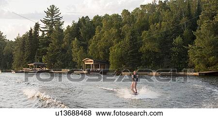 Stock Photo - Girl waterskiing in a lake, Lake of The Woods, Keewatin, Ontario, Canada. Fotosearch