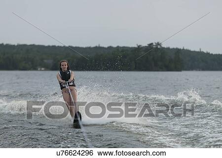 Stock Photograph - Girl waterskiing in a lake, Lake of The Woods, Keewatin, Ontario, Canada. Fotosearch