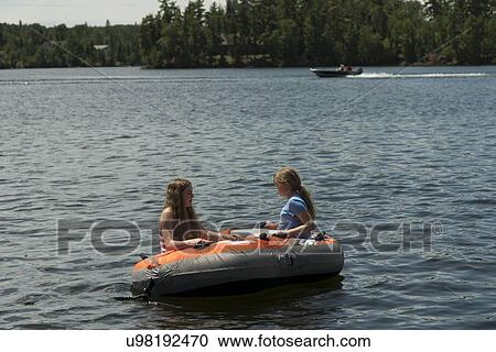 Girls sitting on an inflatable raft in a lake, Lake of The Woods, Keewatin, Ontario, Canada View Large Photo Image Stock Image - Girls sitting on an inflatable raft in a lake, Lake of The Woods, Keewatin, Ontario, Canada. Fotosearch