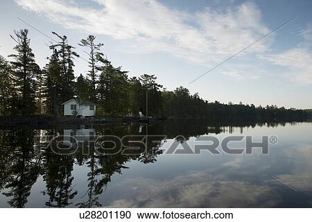 Stock Image - House with trees at Lake of The Woods, Keewatin, Ontario, Canada. Fotosearch
