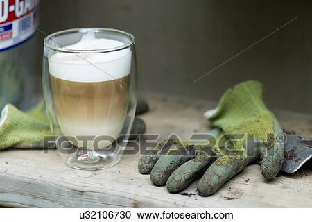 Stock Image - Ice cream float drink with a pair of muddy garden gloves, Lake of The Woods, Keewatin, Ontario, Canada. Fotosearch