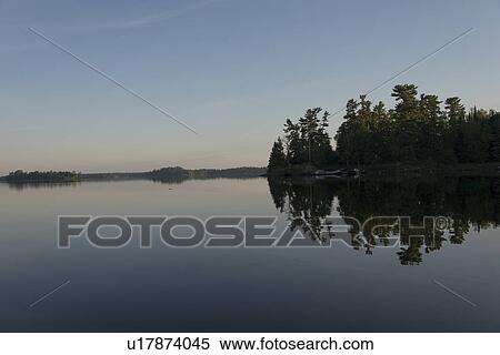Stock Photography - Lake at dawn, Lake Of The Woods, Keewatin, Ontario, Canada. Fotosearch
