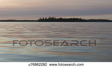 Stock Image - Lake at sunset, Lake Of The Woods, Keewatin, Ontario, Canada. Fotosearch