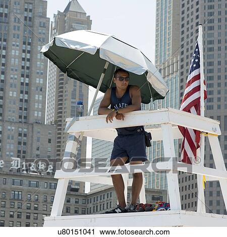 Stock Image - Lifeguard standing on a lifeguard's stand, Chicago, Cook County, Illinois, USA. Fotosearch