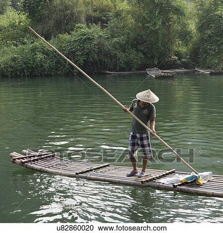 Man on raft in the Yulong River, Yangshuo, Guilin, Guangxi Province, China View Large Photo Image Stock Image - Man on raft in the Yulong River, Yangshuo, Guilin, Guangxi Province, China. Fotosearch