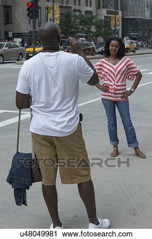 Stock Image - Man taking picture of his wife with a mobile phone, Chicago, Cook County, Illinois, USA. Fotosearch