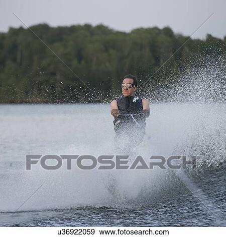 Stock Photo - Man waterskiing in a lake, Lake of The Woods, Keewatin, Ontario, Canada. Fotosearch