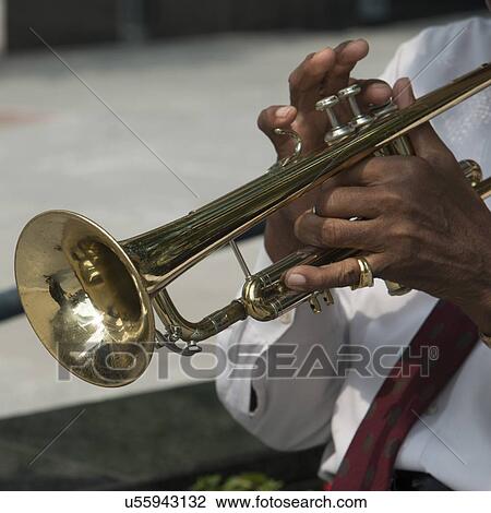 Stock Image - Mid section view of a man playing a trumpet, Chicago, Cook County, Illinois, USA. Fotosearch