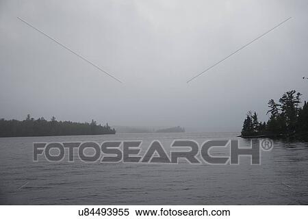 Stock Photography - Mist at dawn, Lake Of The Woods, Keewatin, Ontario, Canada. Fotosearch