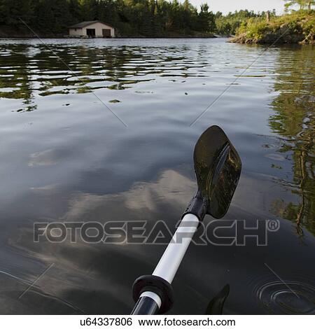 Stock Photograph - Oar above the water surface, Lake of The Woods, Ontario, Canada. Fotosearch