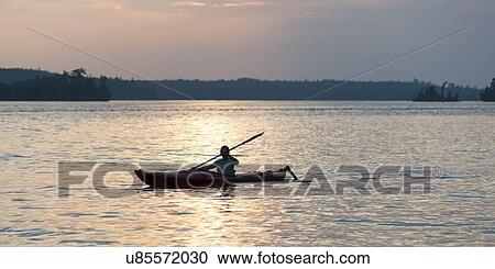 Stock Image - Person boating in the Lake Of The Woods, Keewatin, Ontario, Canada. Fotosearch