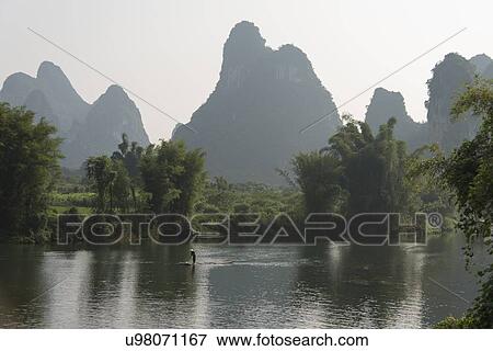 Person on raft in the Yulong River, Yangshuo, Guilin, Guangxi Province, China View Large Photo Image Stock Photo - Person on raft in the Yulong River, Yangshuo, Guilin, Guangxi Province, China. Fotosearch