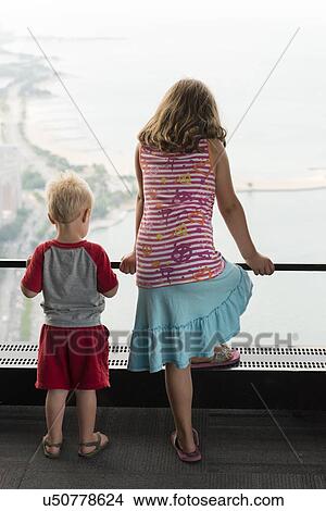 Rear view of a girl and a boy standing at balcony and looking at a view, Chestnut Street, Chicago, Cook County, Illinois, USA View Large Photo Image Picture - Rear view of a girl and a boy standing at balcony and looking at a view, Chestnut Street, Chicago, Cook County, Illinois, USA. Fotosearch