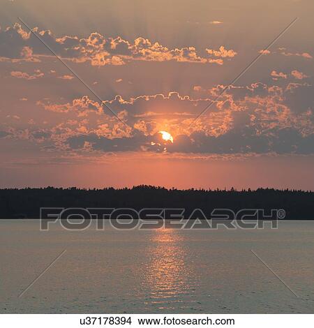 Picture - Reflection of sun through the clouds, Lake of The Woods, Ontario, Canada. Fotosearch