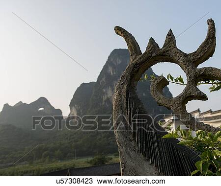Roof of a traditional building with Moon Hill in the background, Yangshuo, Guilin, Guangxi Province, China View Large Photo Image Stock Image - Roof of a traditional building with Moon Hill in the background, Yangshuo, Guilin, Guangxi Province, China. Fotosearch