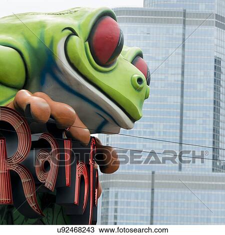 Stock Image - Sculpture of green tree frog atop the Rainforest cafe, Chicago, Cook County, Illinois, USA. Fotosearch