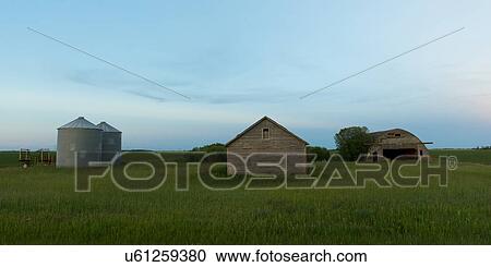 Stock Image - Silo and barn in a prairie field, Manitoba, Canada. Fotosearch