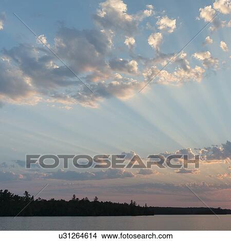 Picture - Sunbeam passing through clouds in the sky, Ontario, Canada. Fotosearch