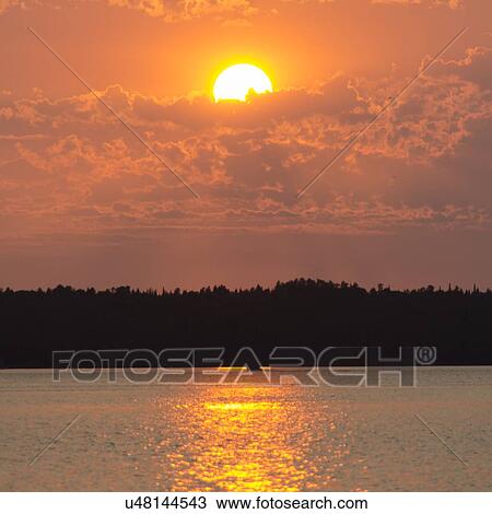 Stock Image - Sunset over a lake, Lake of The Woods, Ontario, Canada. Fotosearch