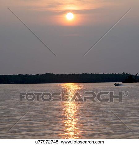Stock Photography - Sunset over a lake, Lake of The Woods, Ontario, Canada. Fotosearch