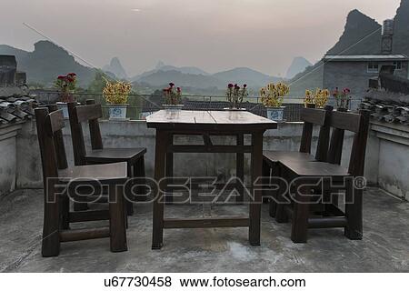 Stock Photo - Table and chairs on the terrace of a house, Yangshuo, Guilin, Guangxi Province, China. Fotosearch