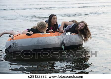 Three girls enjoying on inflatable raft in the lake, Lake Of The Woods, Keewatin, Ontario, Canada View Large Photo Image Stock Image - Three girls enjoying on inflatable raft in the lake, Lake Of The Woods, Keewatin, Ontario, Canada. Fotosearch