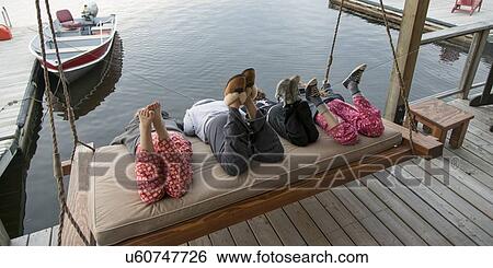 Three girls enjoying on swing chair at a dock, Lake Of The Woods, Keewatin, Ontario, Canada View Large Photo Image Stock Photograph - Three girls enjoying on swing chair at a dock, Lake Of The Woods, Keewatin, Ontario, Canada. Fotosearch