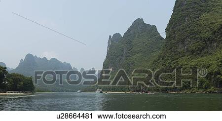 Stock Image - Tourboats in the Li River with mountains in the background, Yangshuo, Guilin, Guangxi Province, China. Fotosearch