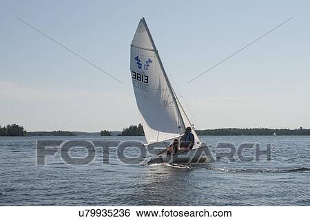 Stock Photograph - Tourists in a sailboat, Lake of The Woods, Kenora, Ontario, Canada. Fotosearch