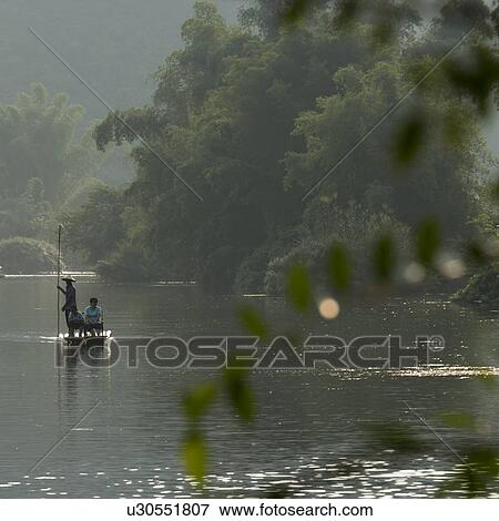 Tourists on a bamboo raft in Yulong River, Yangshuo, Guilin, Guangxi Province, China View Large Photo Image Stock Photo - Tourists on a bamboo raft in Yulong River, Yangshuo, Guilin, Guangxi Province, China. Fotosearch
